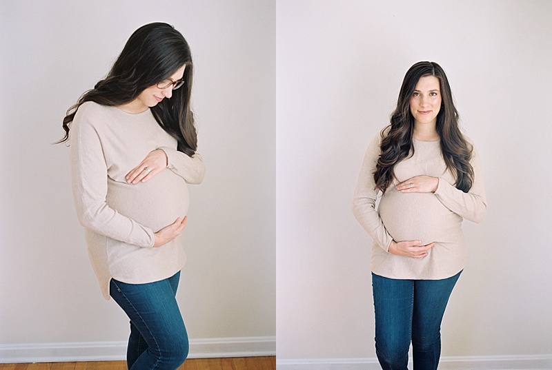 Pregnant woman holds and admires the baby in her belly.