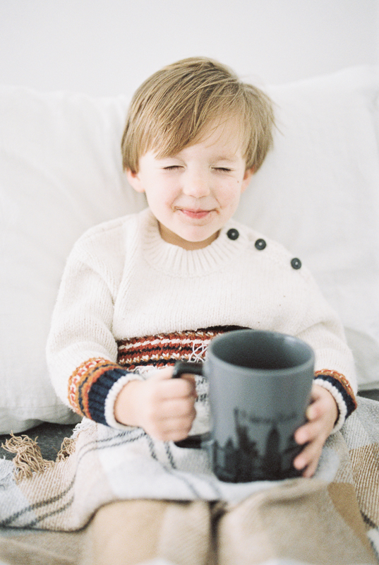 Small child smiles while drinking hot chocolate. 
