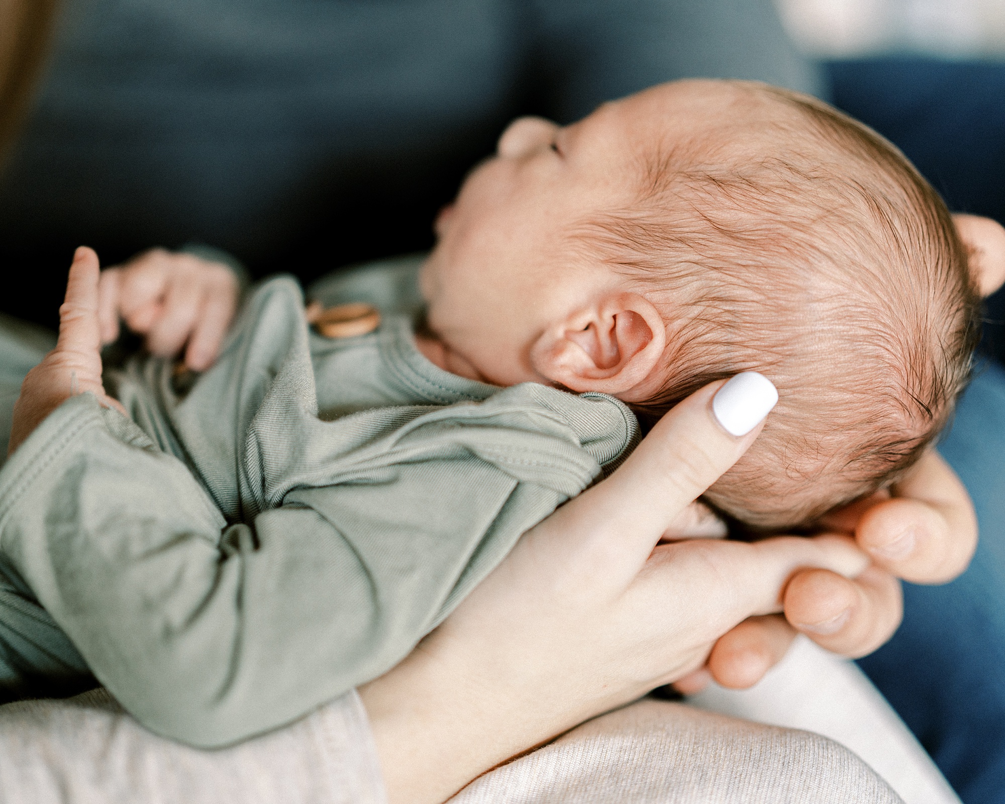 mom supports baby boy's head on lap during Murfreesboro TN In Home Lifestyle Newborn photos