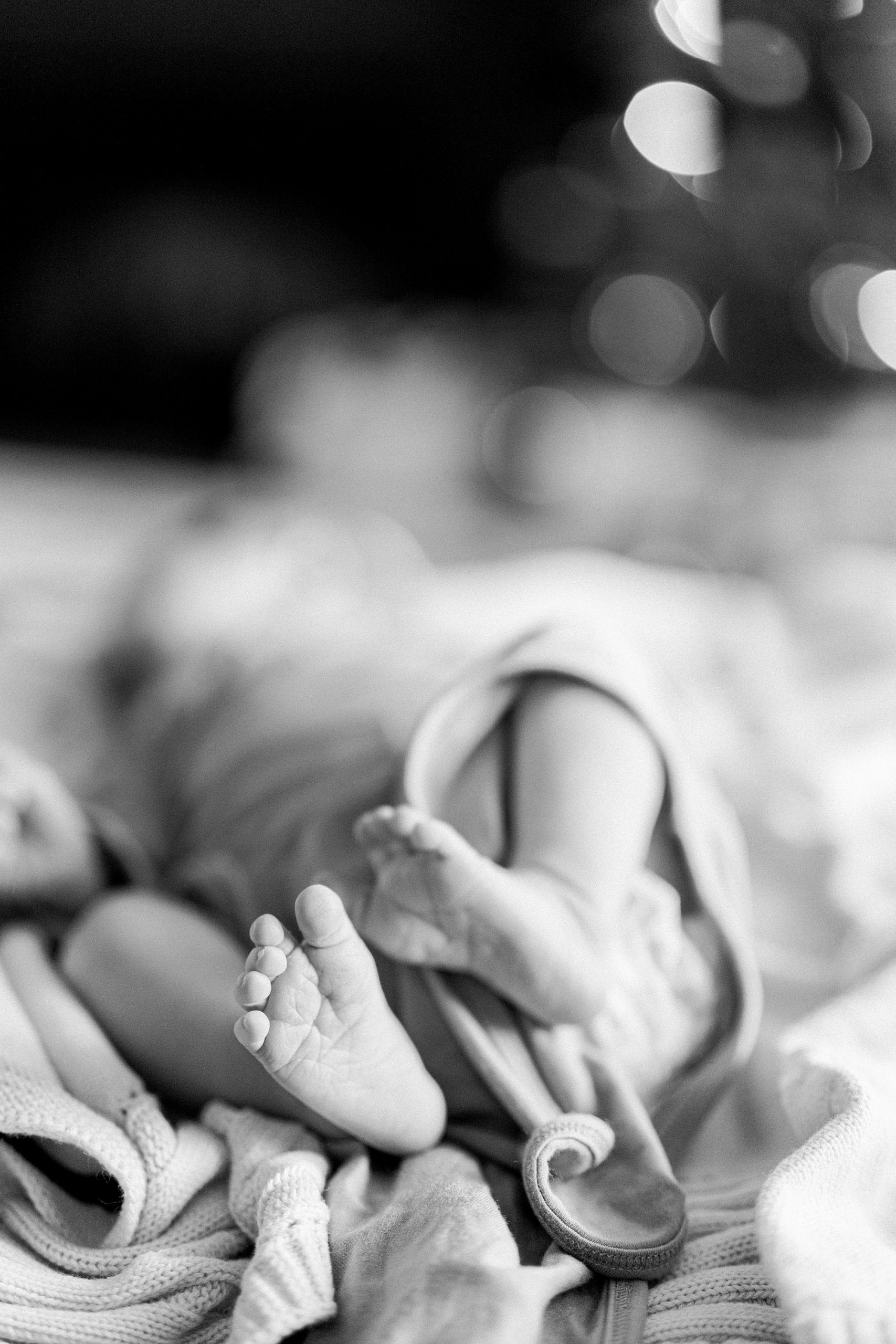 baby feet poke out of blanket during In Home Lifestyle Newborn photos