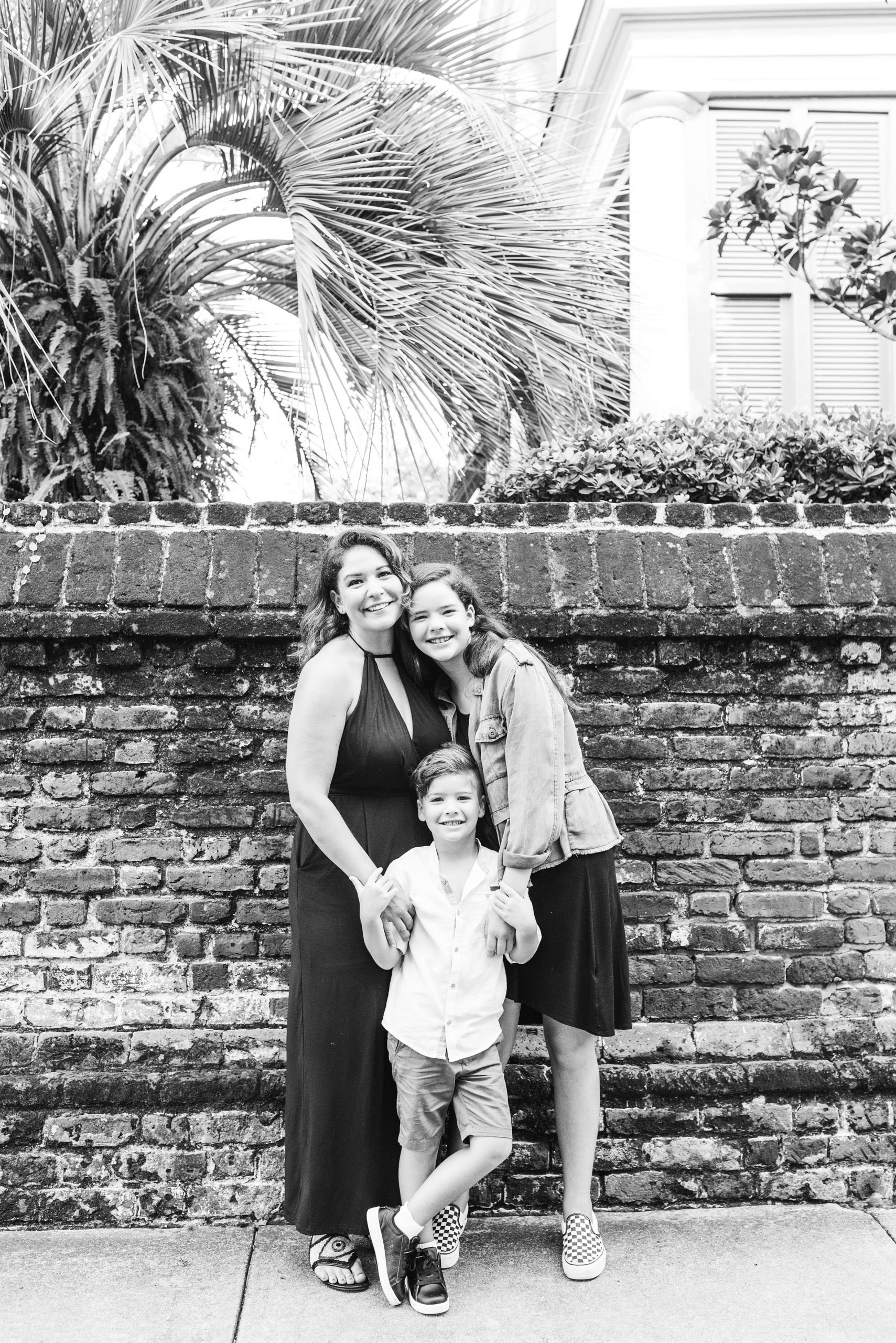 Charleston family session with mom hugging kids by brick wall