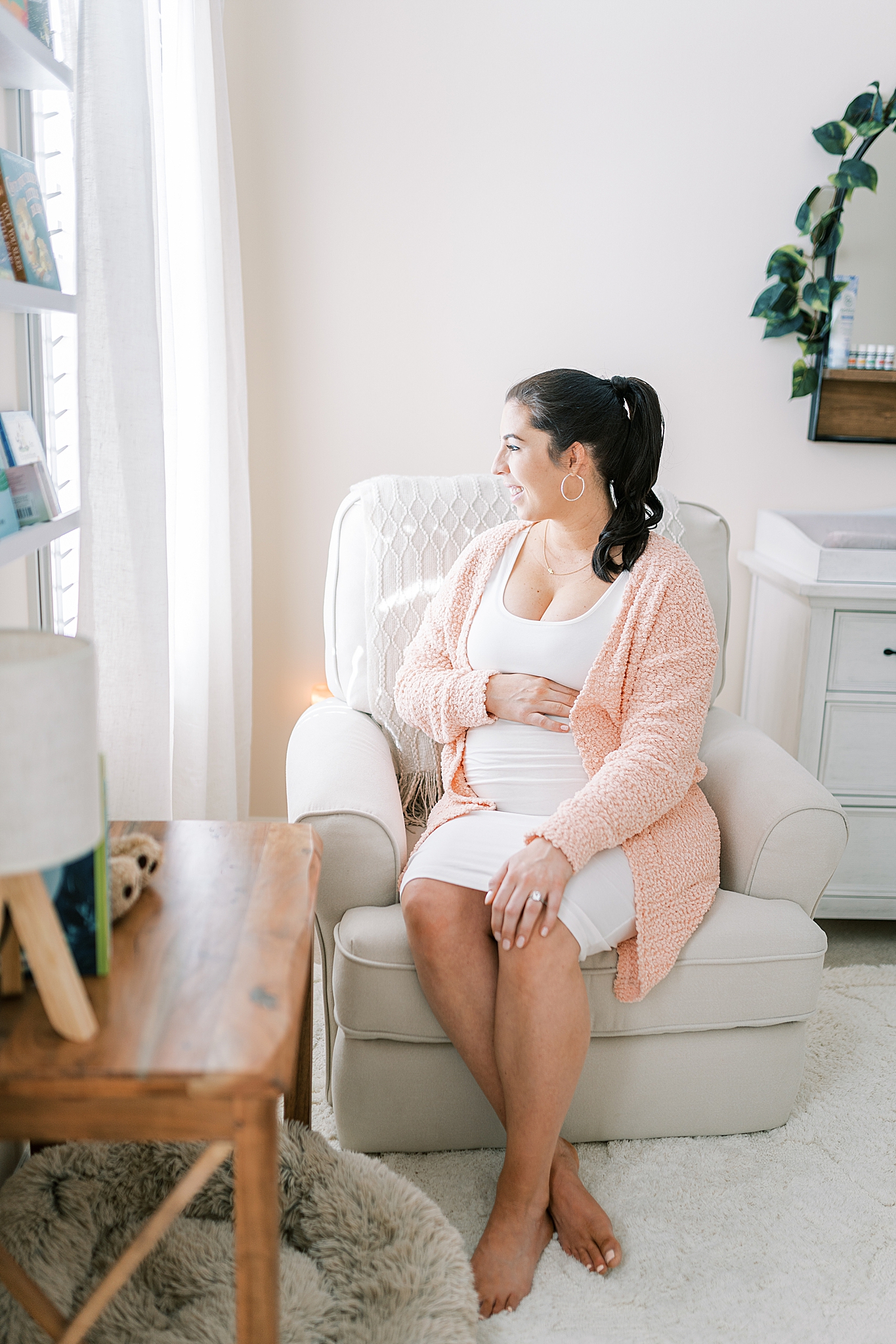 mom sits in rocker looking out window during Murfreesboro lifestyle maternity session