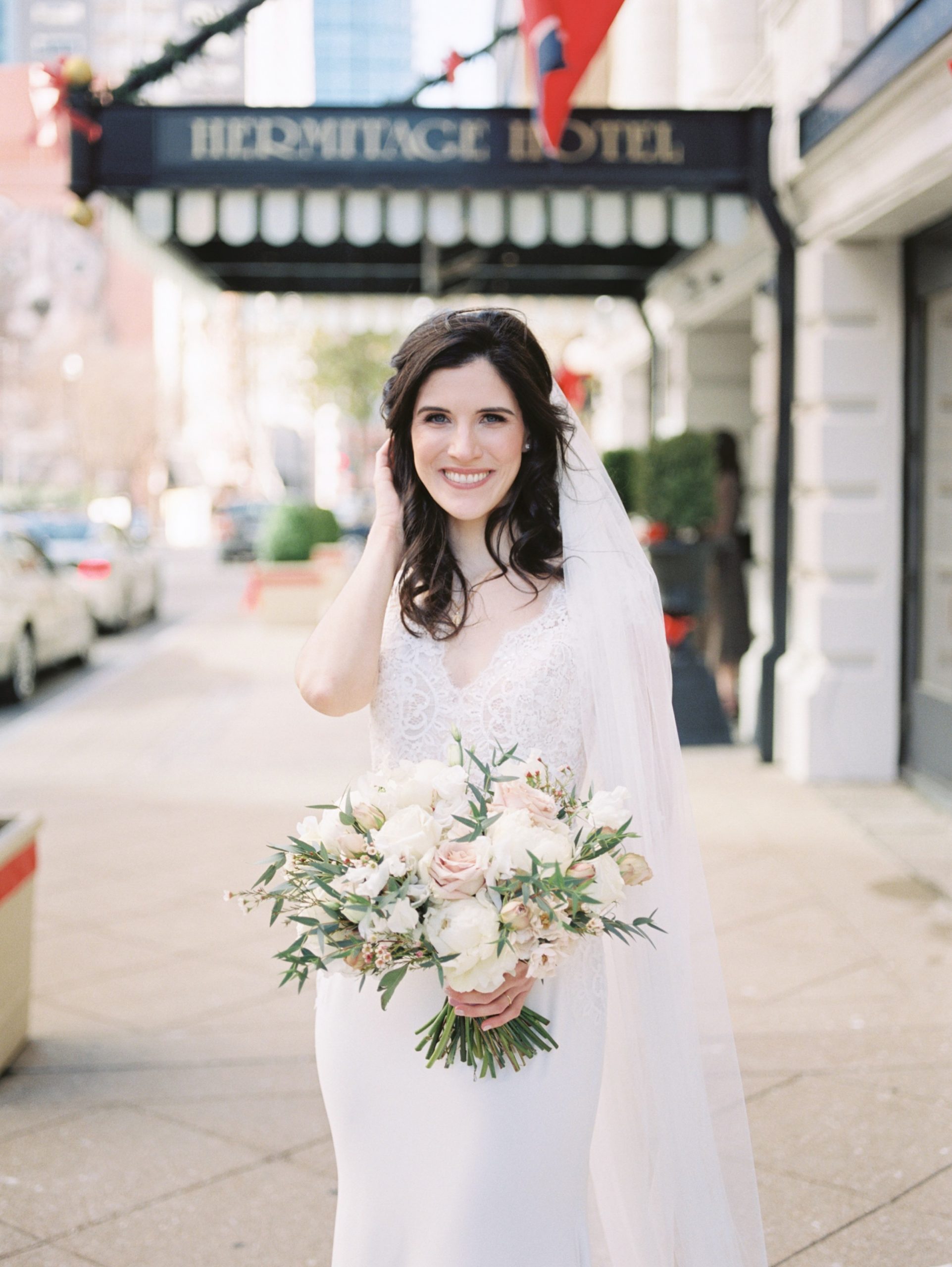 bride holds bouquet outside Hermitage Hotel