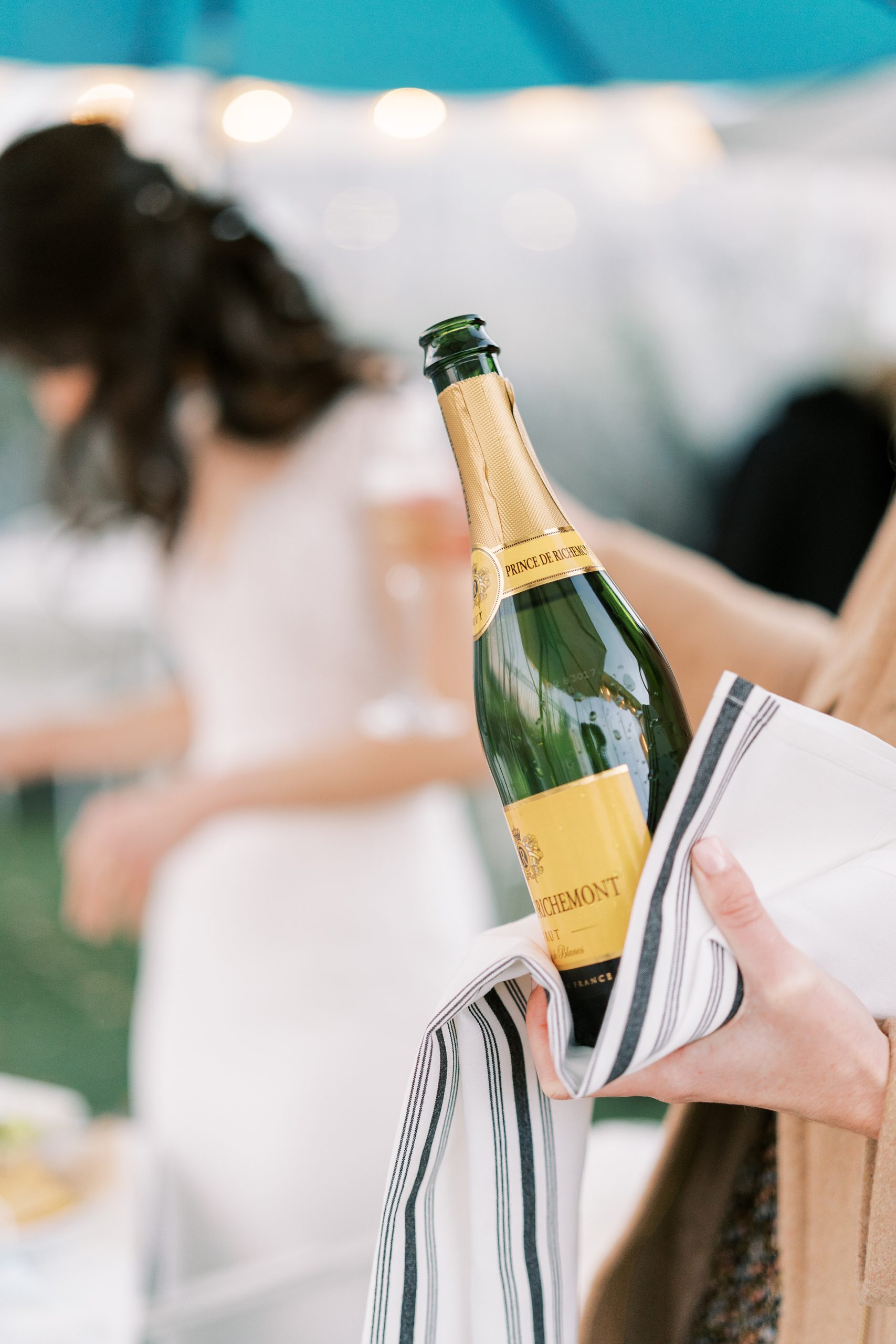 bride and groom toast with bottle of champagne