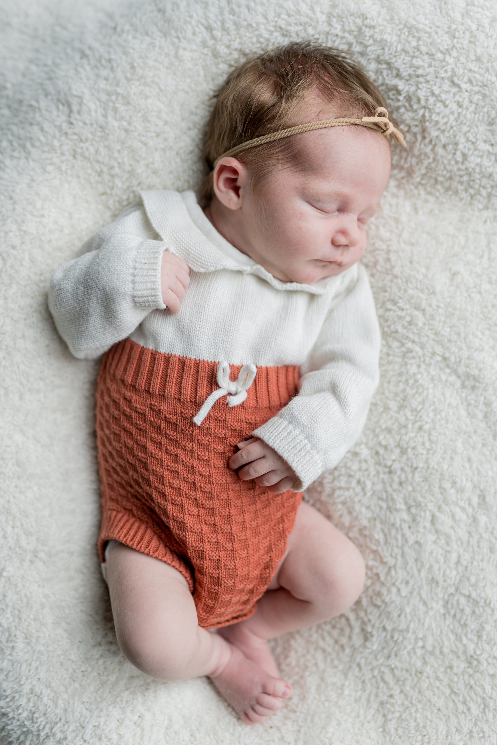 baby girl in knit outfit sleeps during Nashville lifestyle newborn portrait session