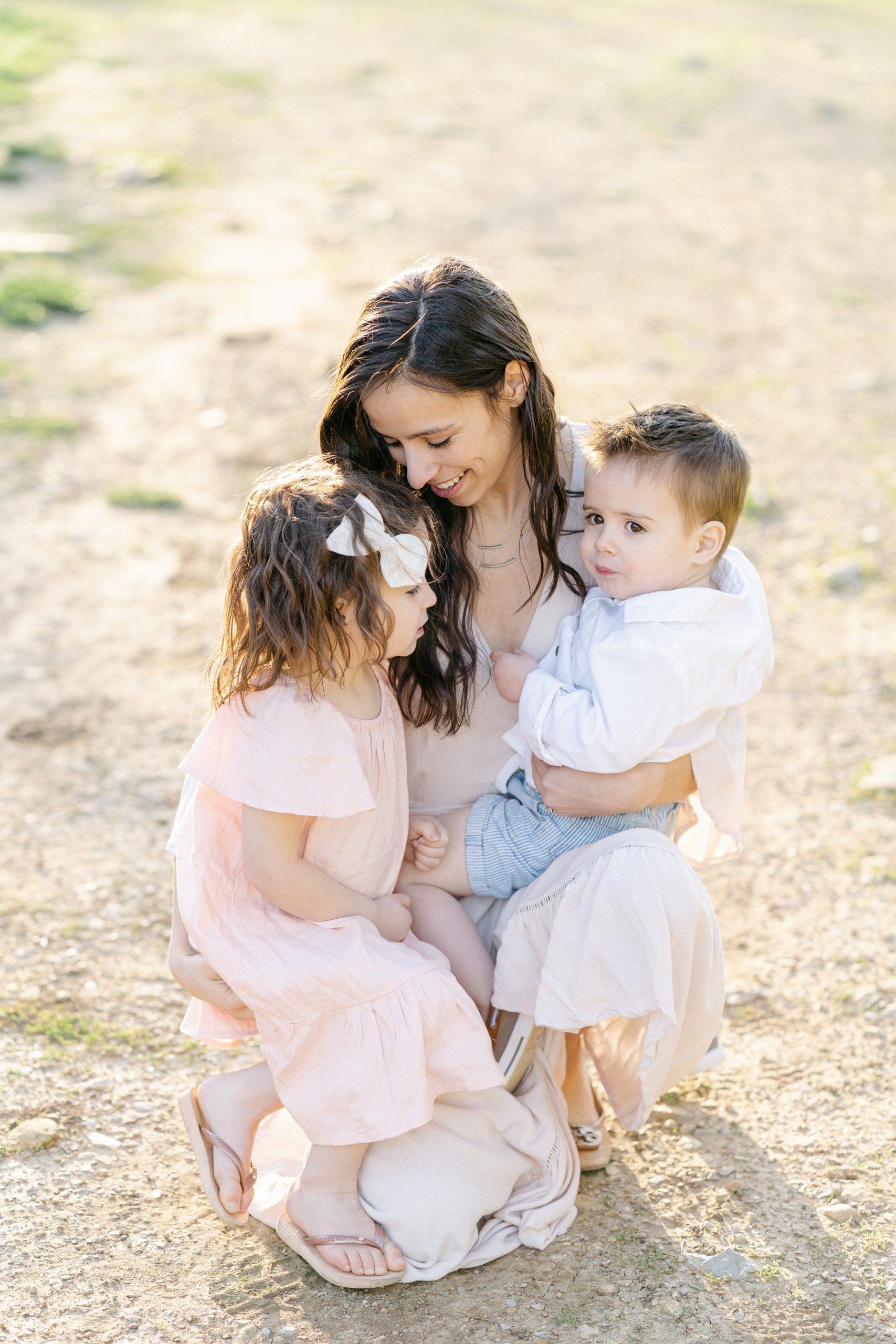 mom hugs two young children during spring Brentwood family portraits