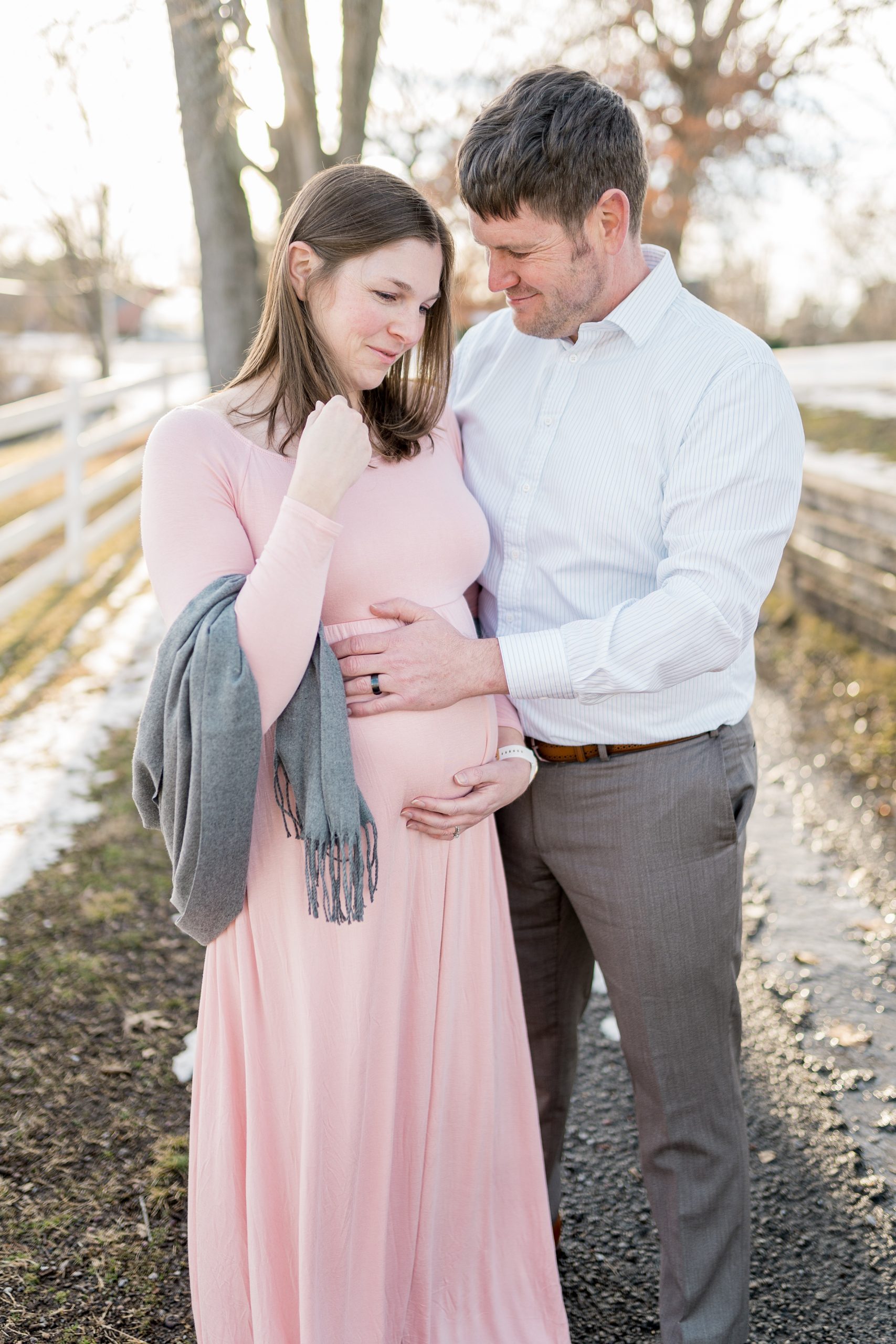 dad touches mom's belly during TN maternity photos in the snow