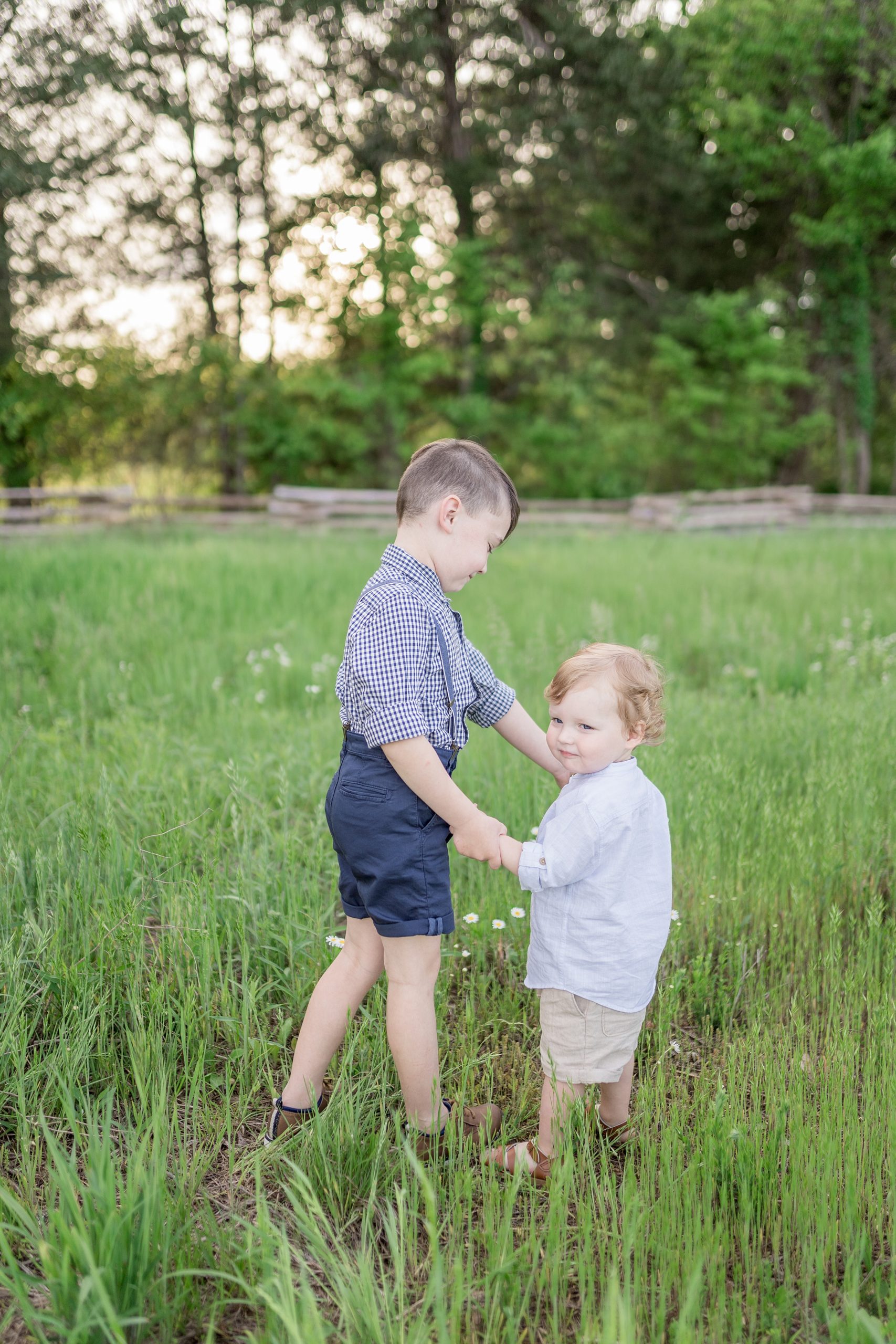 brothers hold hands and spin in field during Murfreesboro TN Family Session
