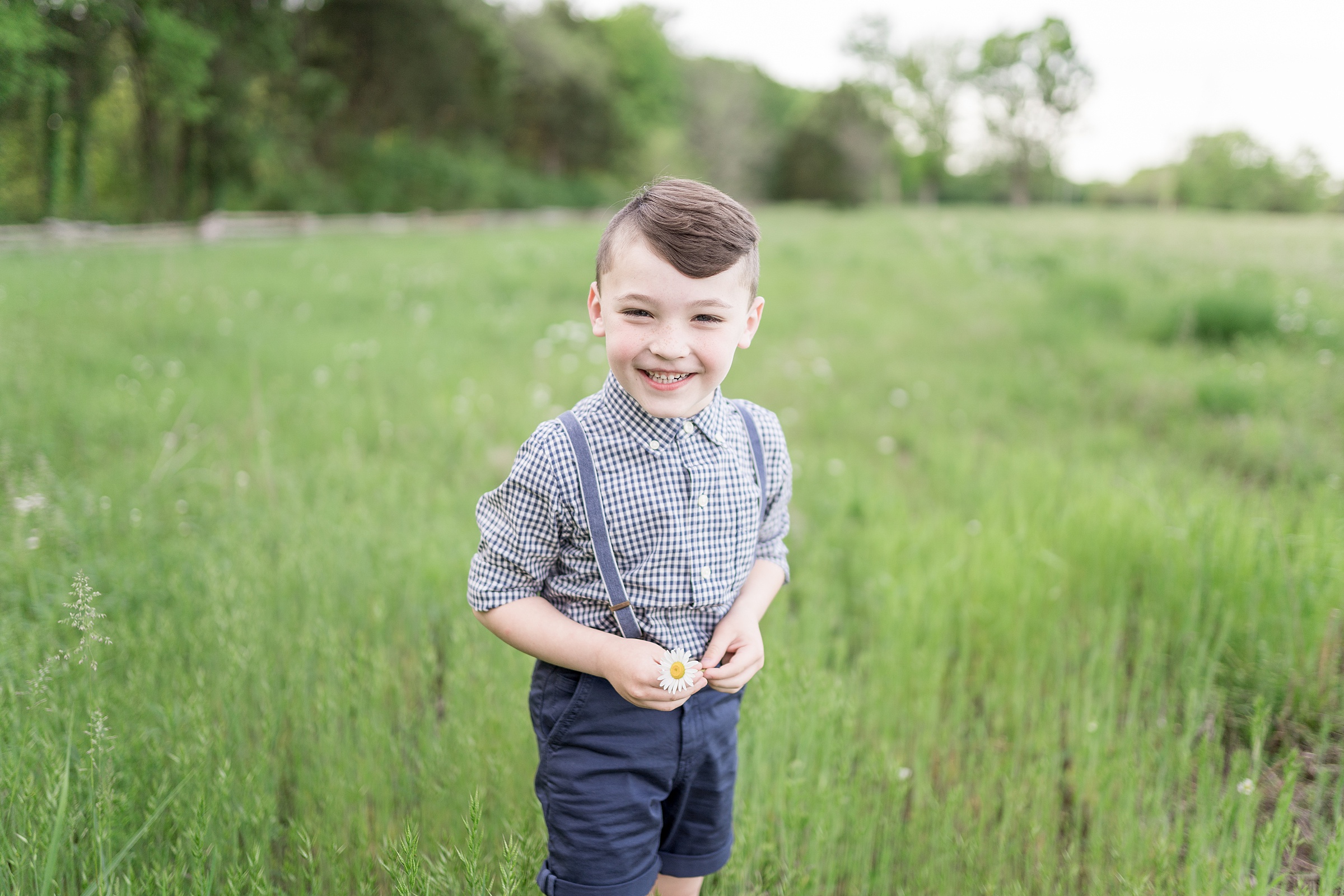 older brother poses for photo in grass