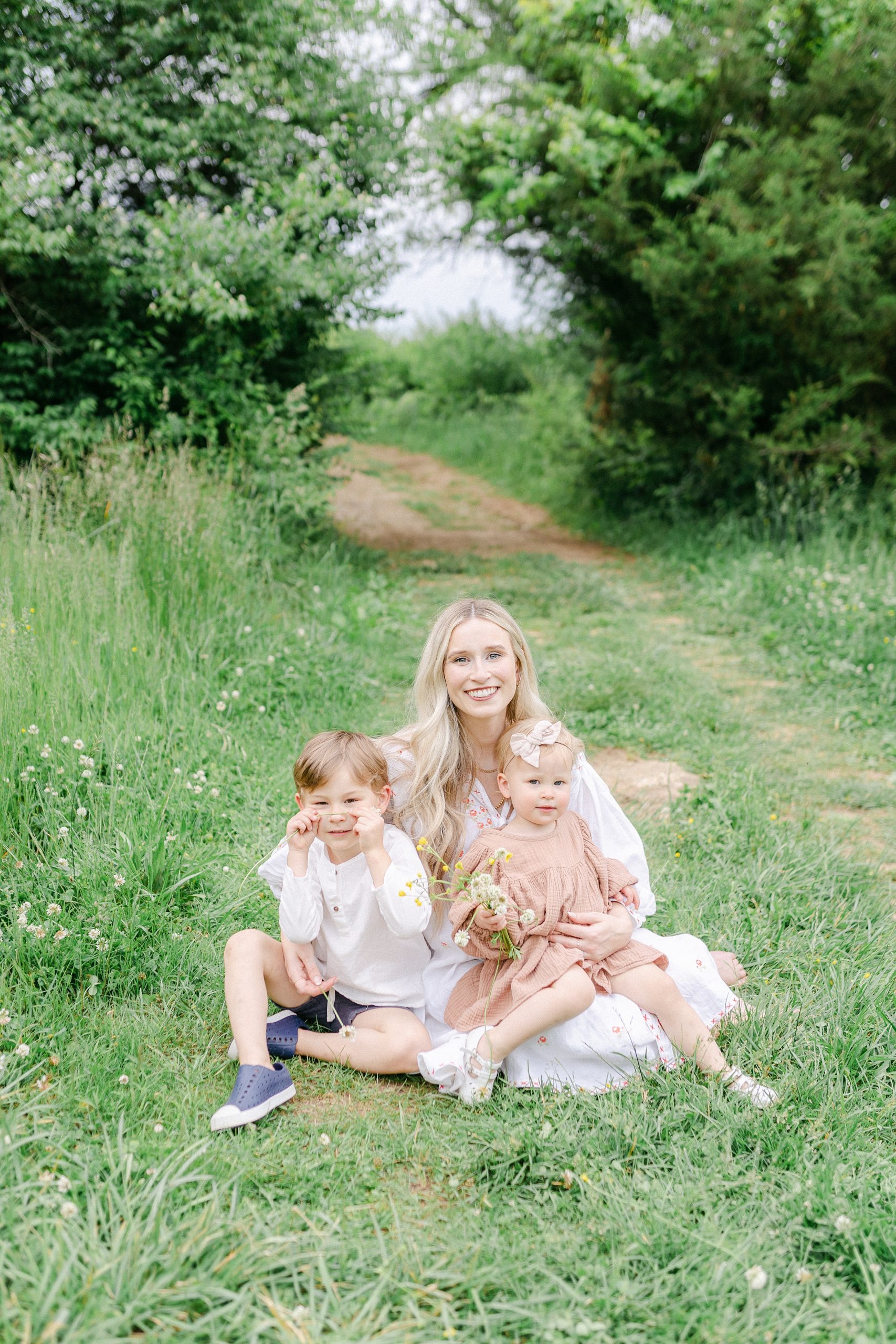 mom holds kids sitting in TN field during Mom + Me Session by Grace Paul Photography