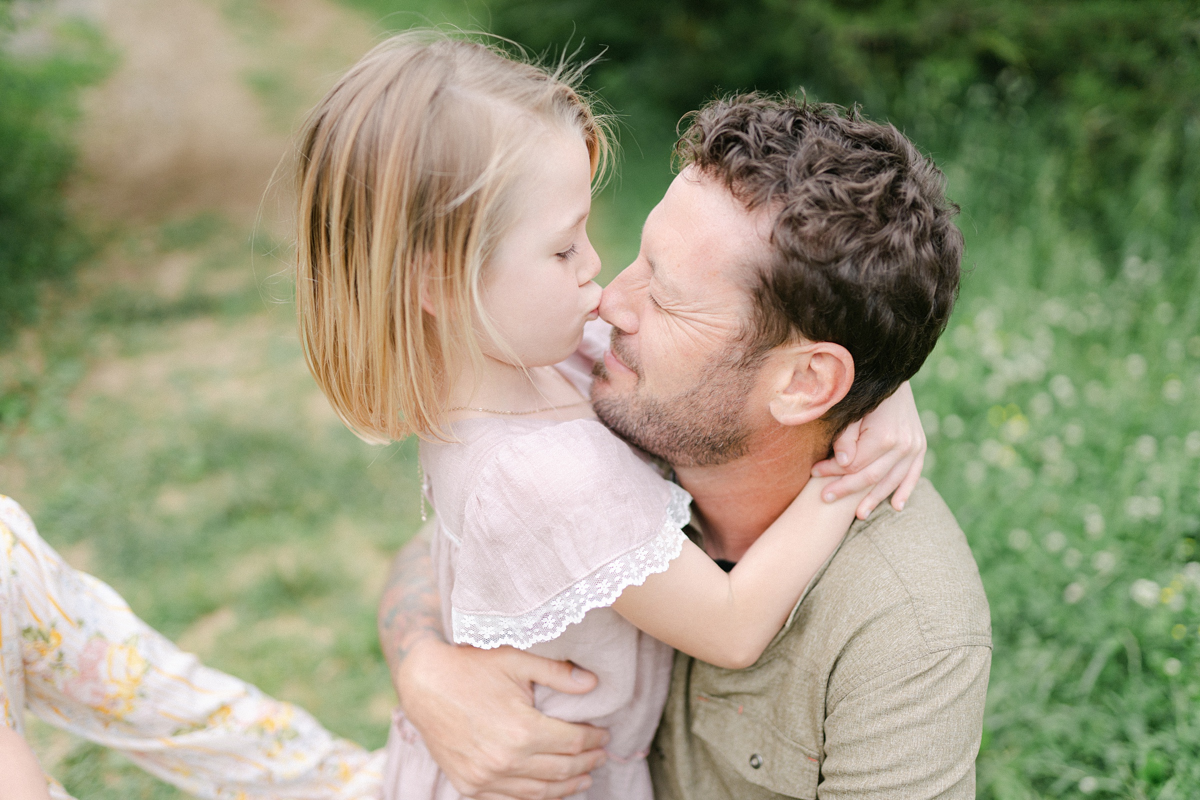 daughter hugs her daddy and kisses his nose during TN family photos