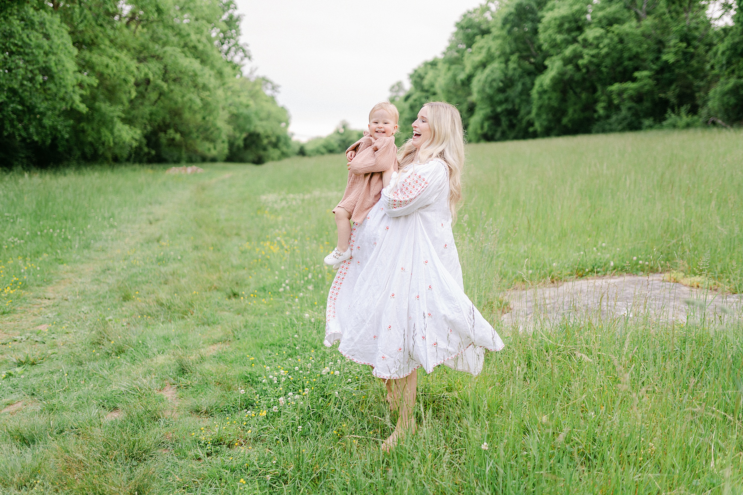 Mom holds daughter in field of Brentwood TN during Mom + Me MaternitySession by Grace Paul Photography