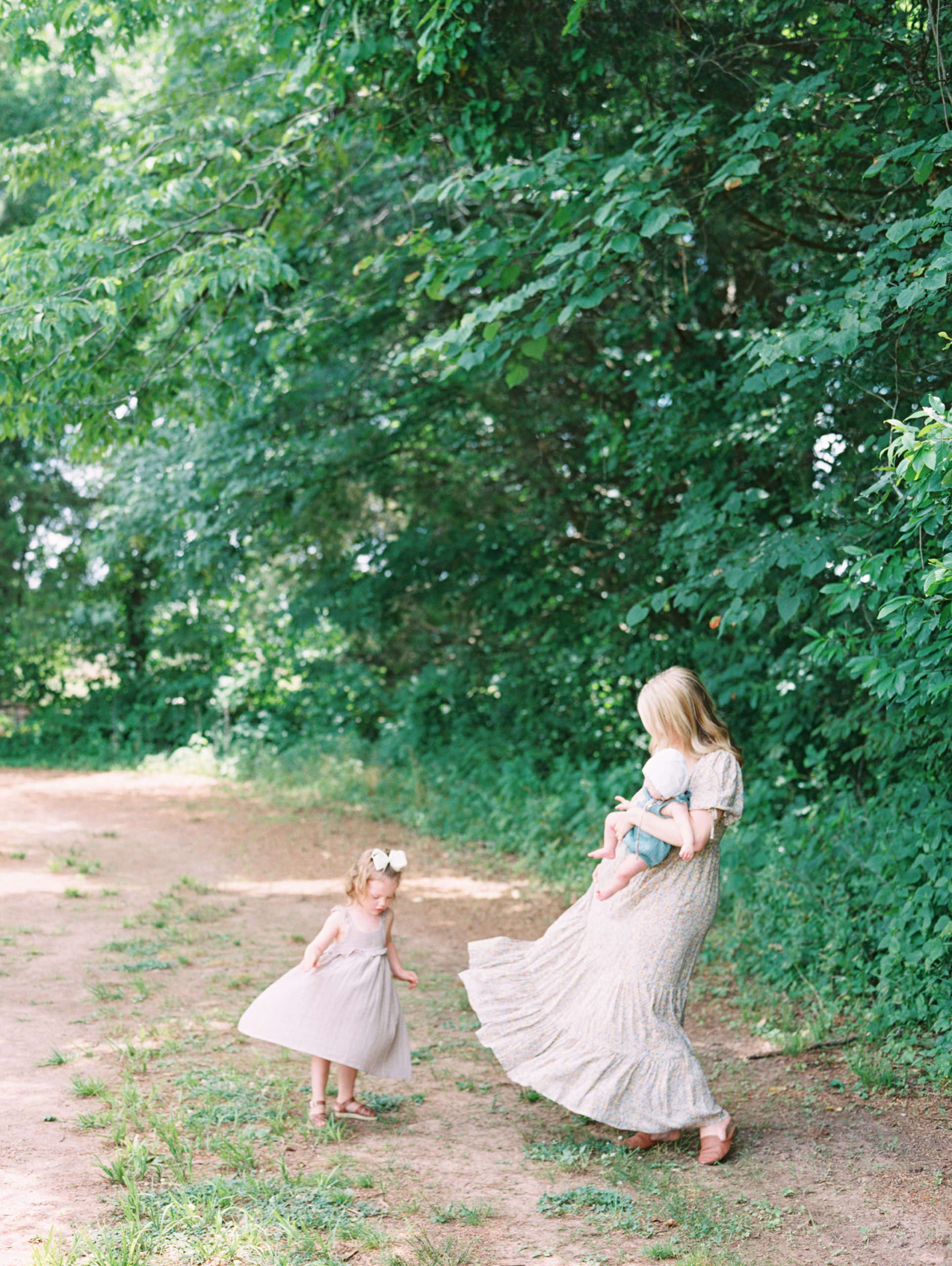 Candid photo of Mother + daughter twirling around in flowy dresses