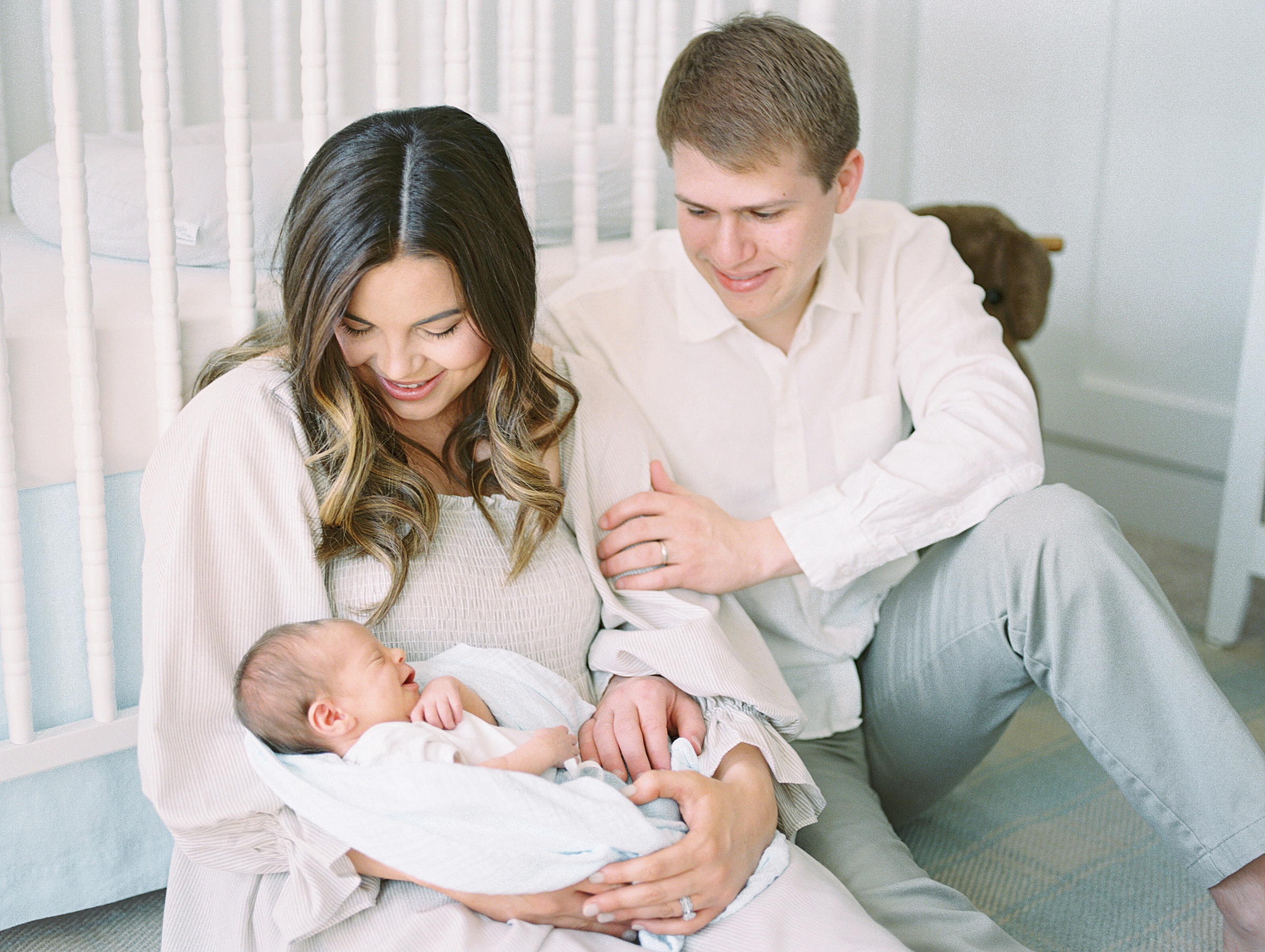 New parents admire their newborn baby boy during in-home newborn session