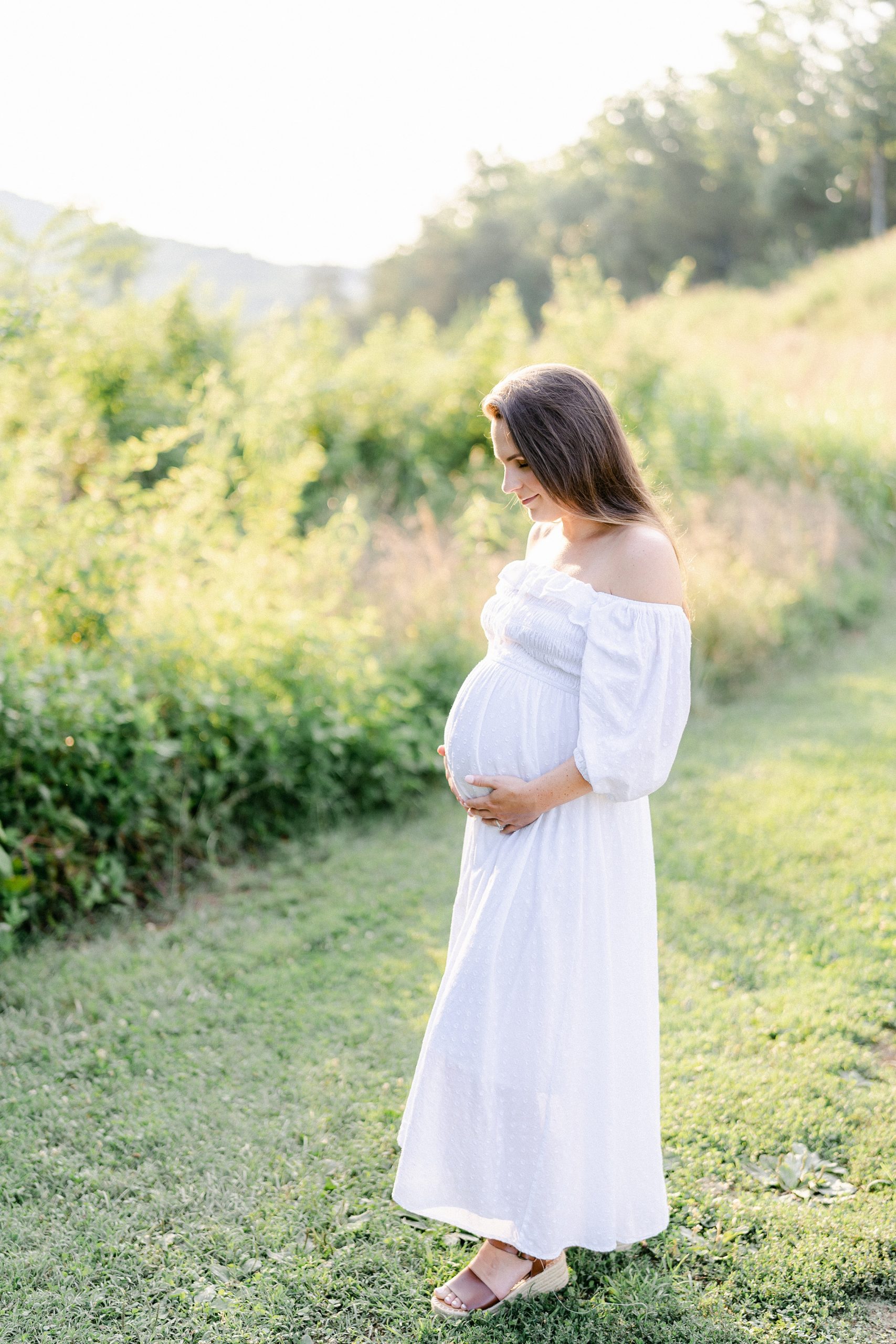 mom to be walks along grass path during TN maternity session