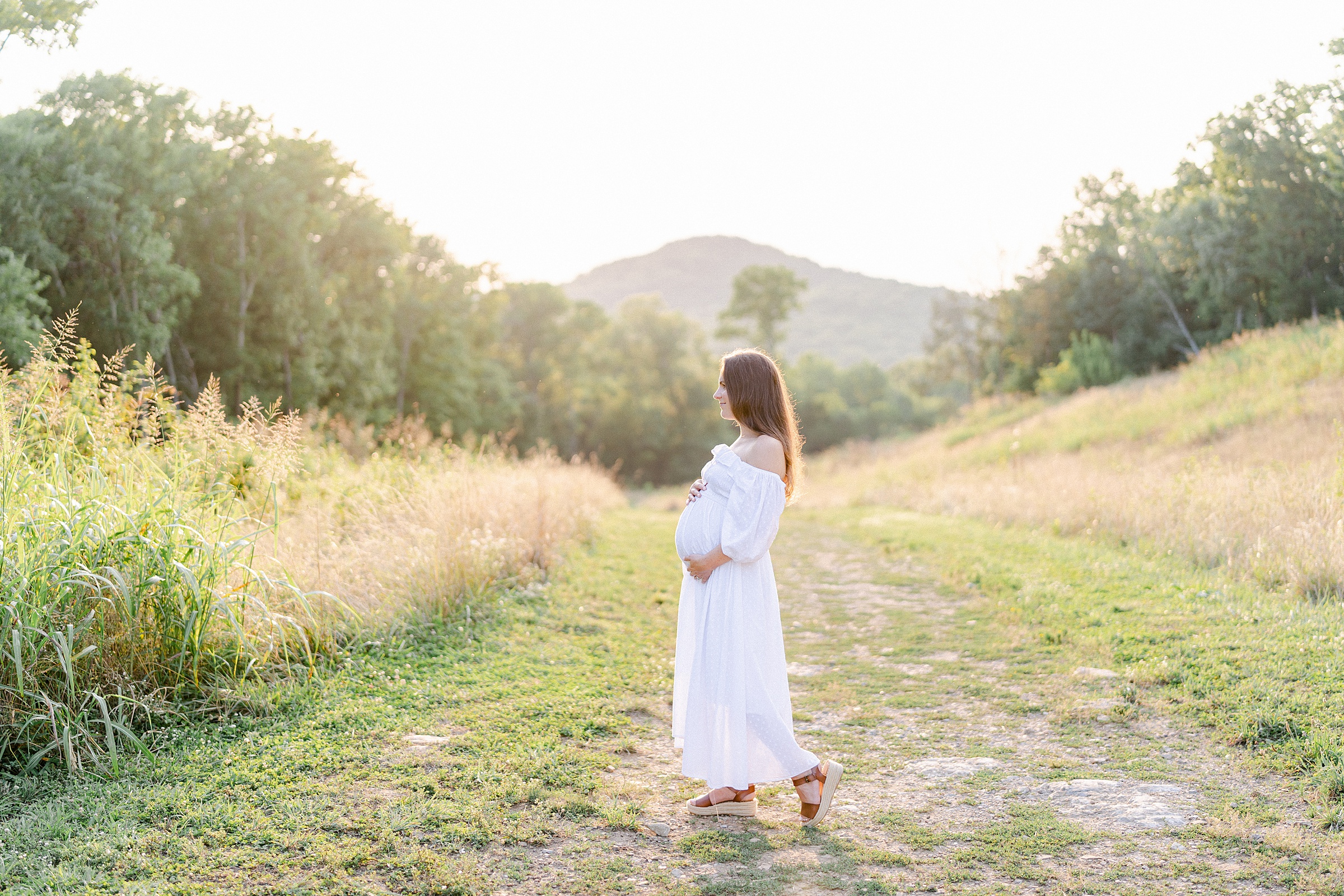 pregnant woman walks along grass path during TN maternity session