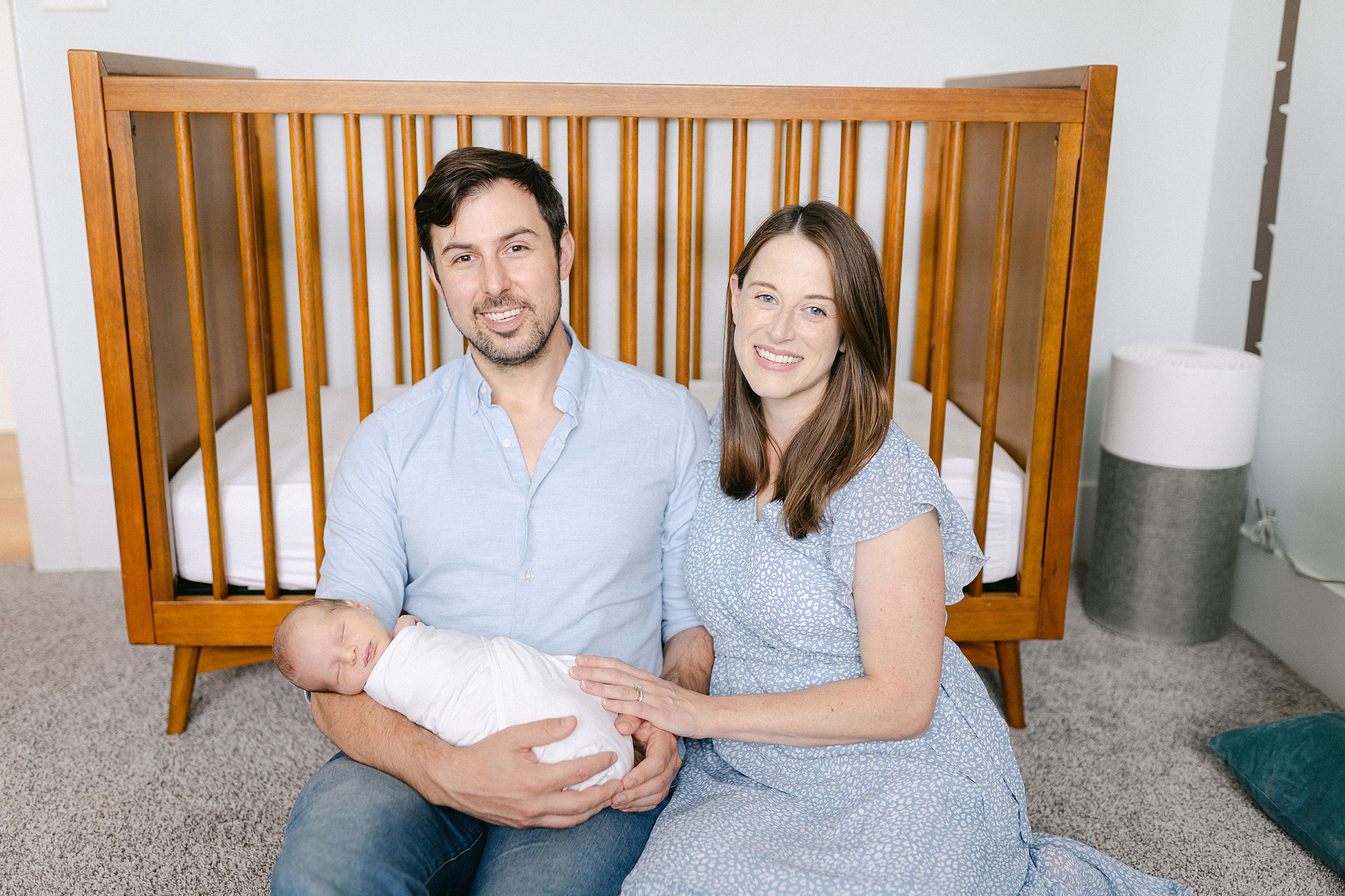 parents hold newborn son on floor of nursery during in-home Nashville Lifestyle Newborn Session