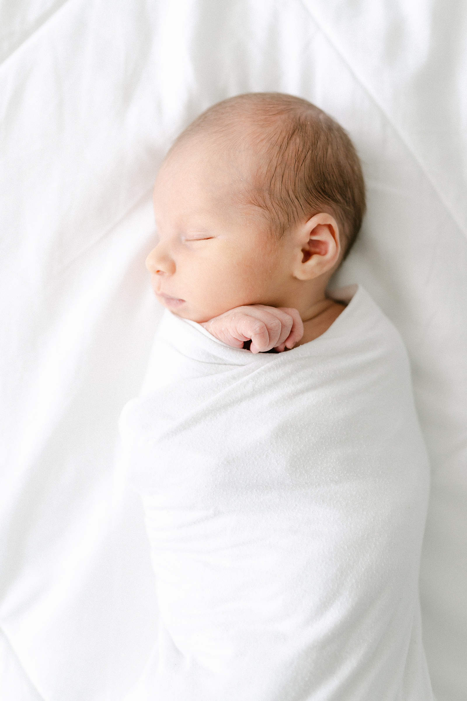 newborn baby boy wrapped in white blanket