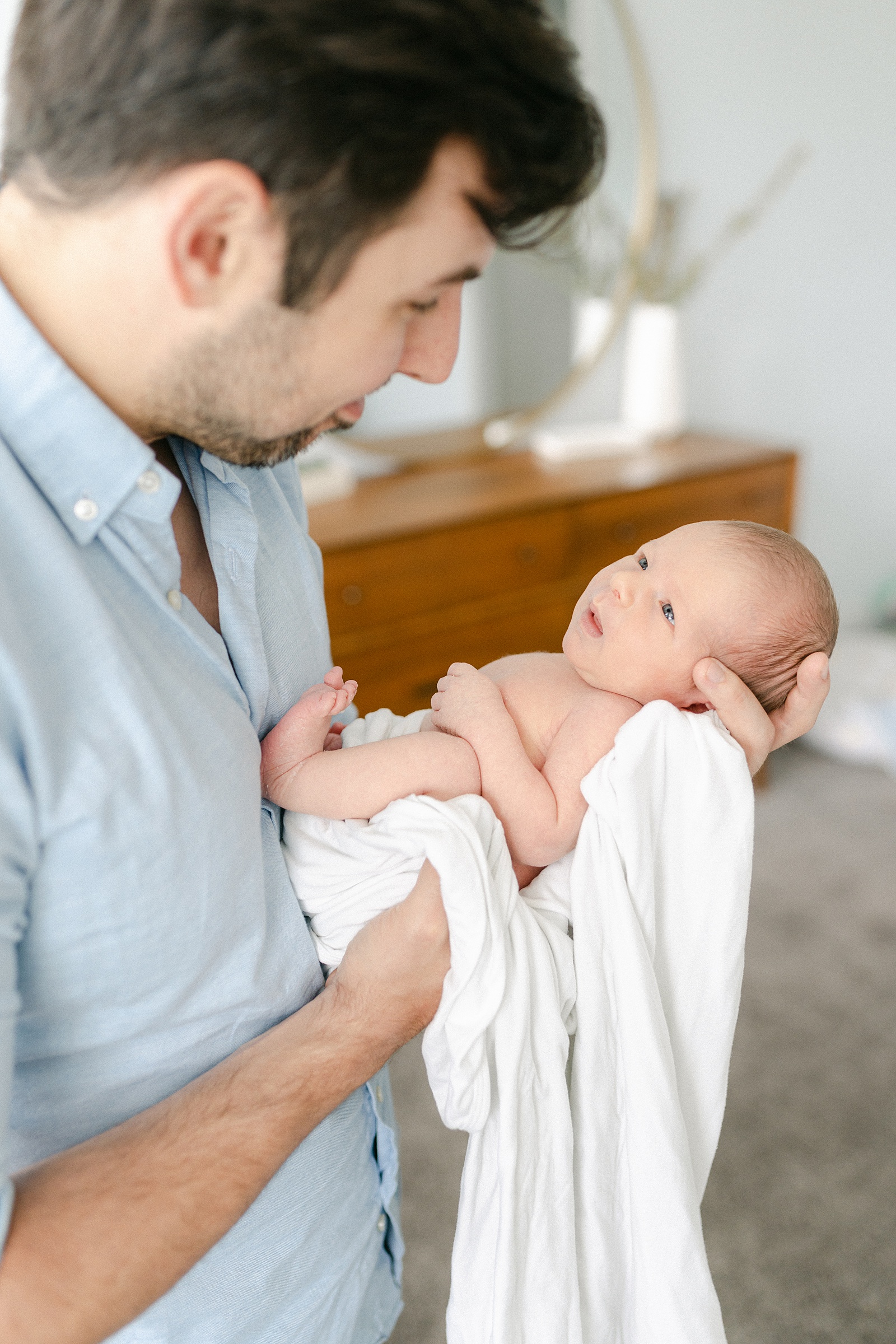 Baby boy looks up at his dad during Nashville Lifestyle Newborn Session captured by Grace Paul Photography