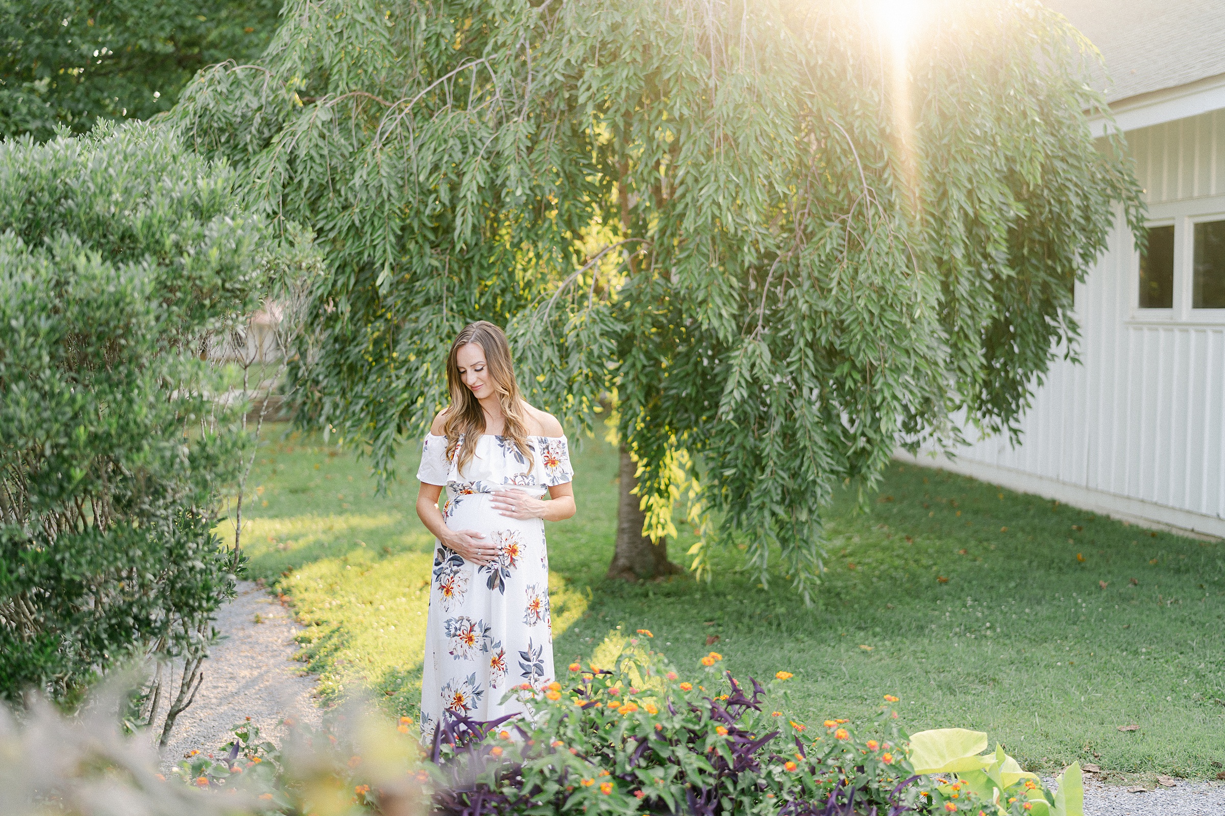 mom holds baby bump under cascading green trees at Nashville Ellington Agricultural Center by Grace Paul Photography