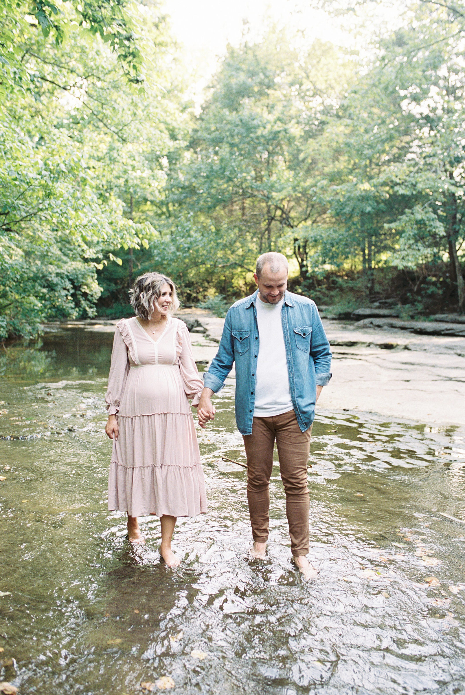 couple walks through stream in wooded area of Ellington Agricultural Center in TN