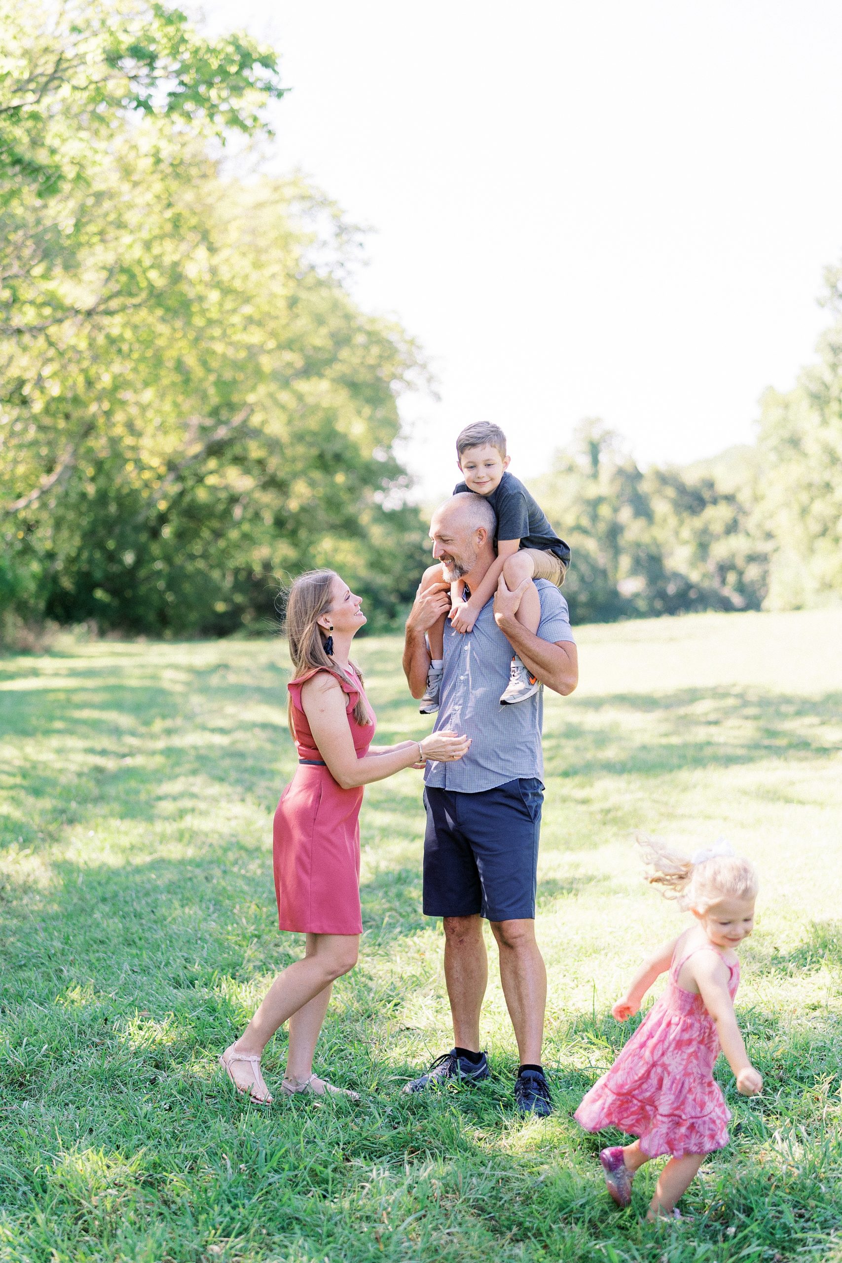 family of four play in the field during Brentwood Fall Family session